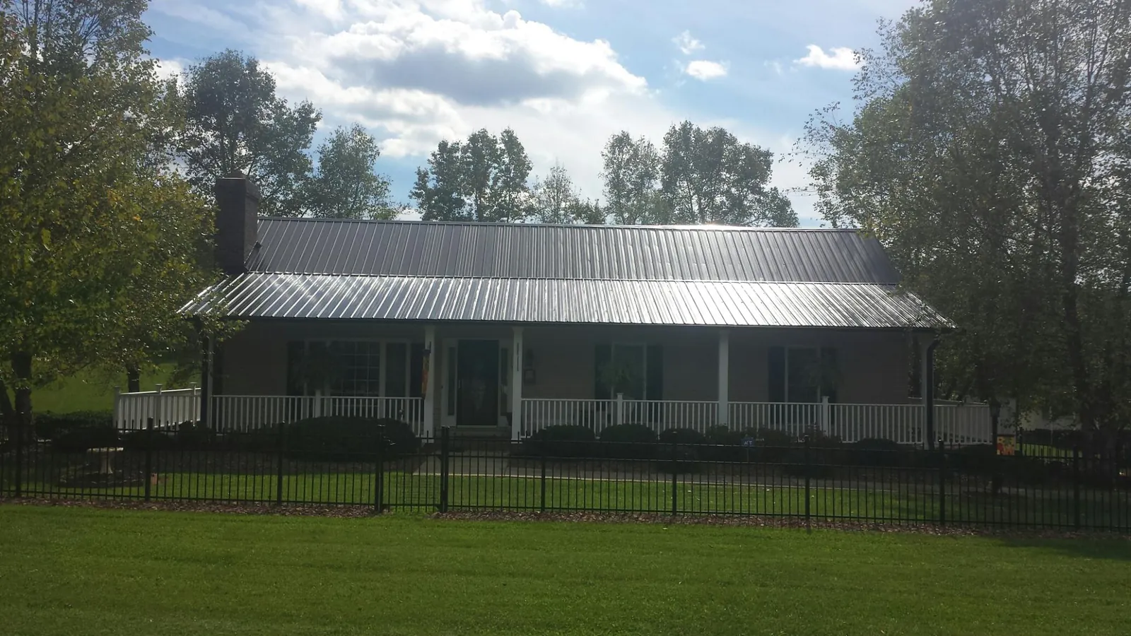 Gray metal roof on a brick ranch with a full width front porch — Gutter Guard Installation work by our crew in Damascus